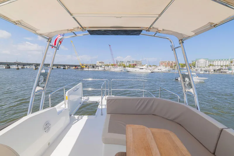 Slide: The Image of 2019 Beneteau Swift Trawler 35, spacious deck view, marina backdrop, sunny day. - 35