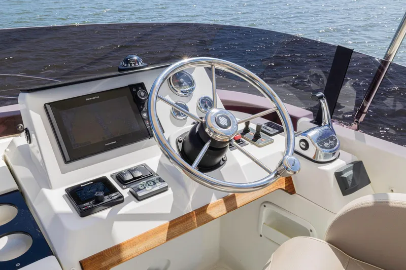 Slide: The Image of 2019 Beneteau Swift Trawler 35 helm with steering wheel and navigation controls. - 40