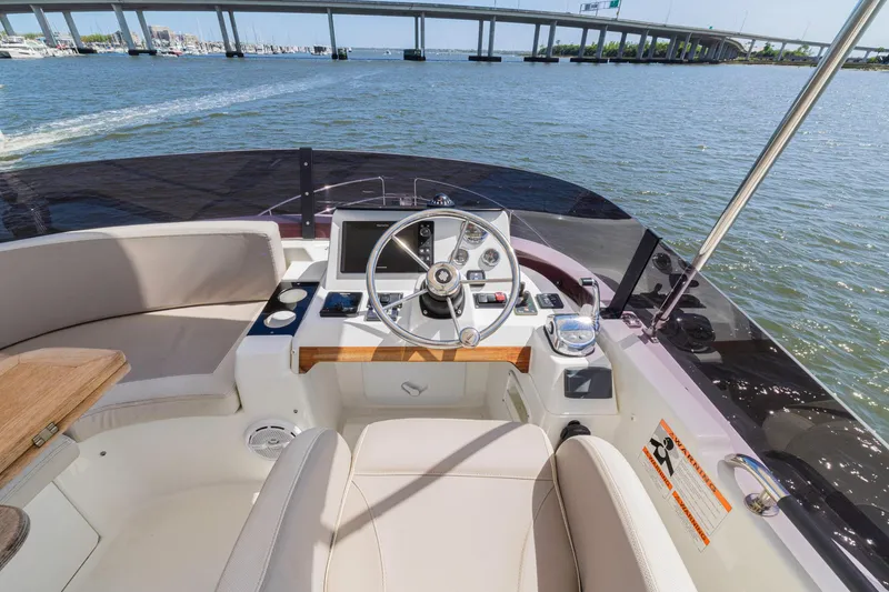 Slide: The Image of 2019 Beneteau Swift Trawler 35 helm with scenic waterway and bridge view. - 41