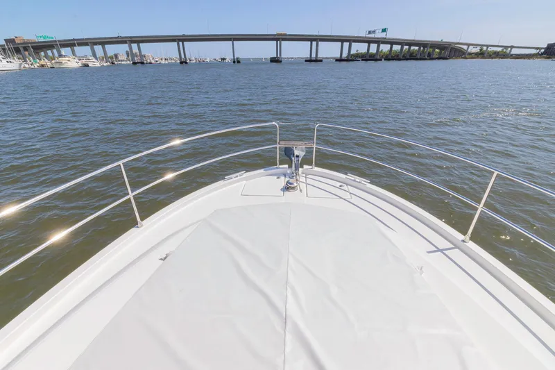 Slide: The Image of Bow view of 2019 Beneteau Swift Trawler 35 on open water near a bridge. - 43