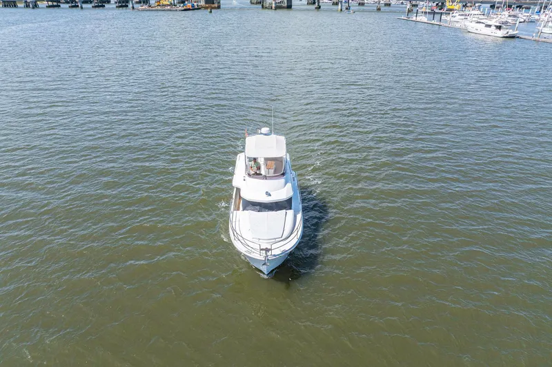 Slide: The Image of 2019 Beneteau Swift Trawler 35 cruising on open water near a marina. - 54