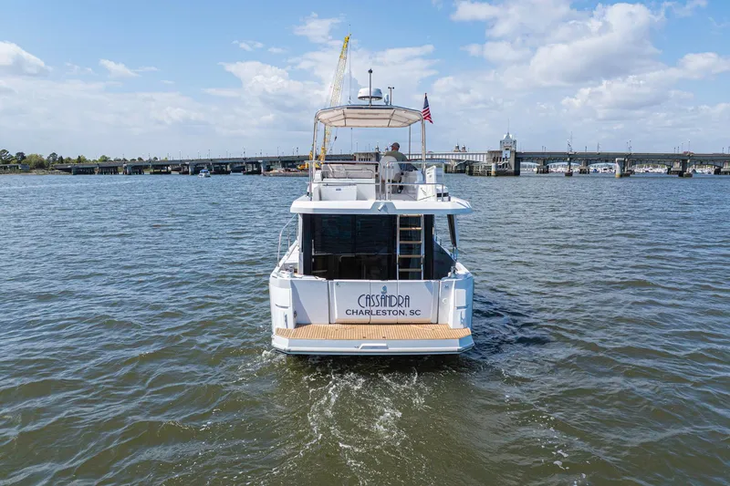 Slide: The Image of 2019 Beneteau Swift Trawler 35 cruising near a bridge under a partly cloudy sky. - 55