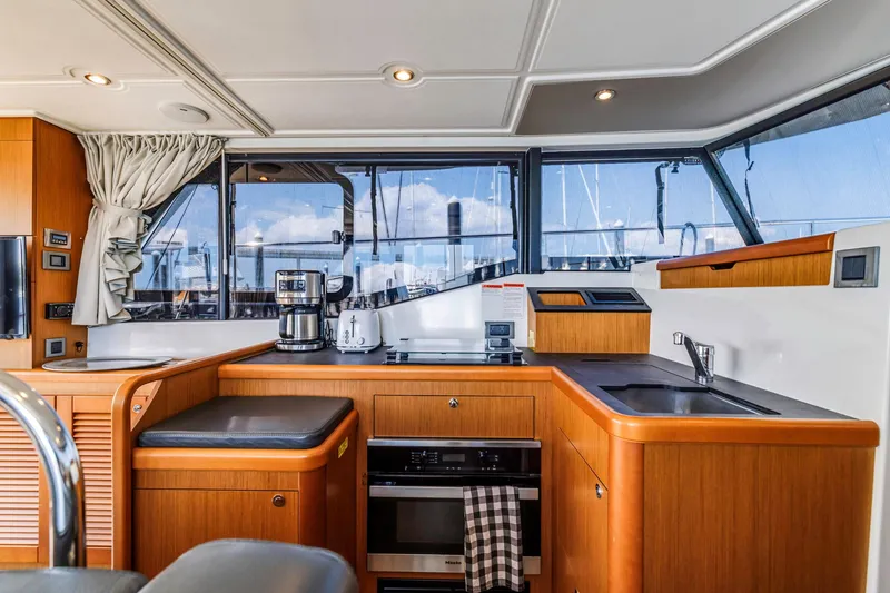 Slide: The Image of Interior of 2019 Beneteau Swift Trawler 35 kitchen with modern appliances and wood finish. - 57