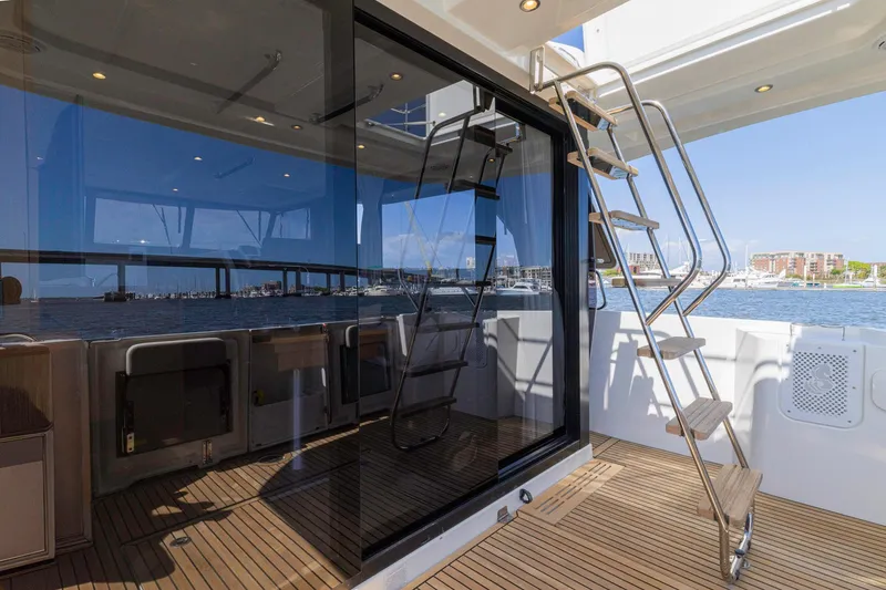 Slide: The Image of 2019 Beneteau Swift Trawler 35 with sleek deck and modern glass doors, overlooking marina. - 58