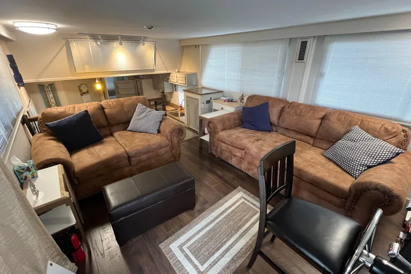 Slide: The Image of Cozy 1995 WaveLenth Wide Body interior with brown sofas, pillows, and modern decor. - 2