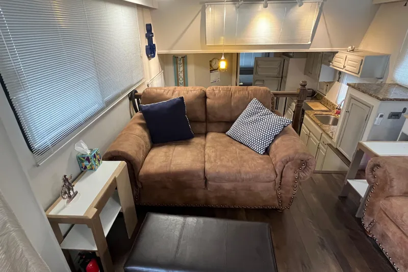 Slide: The Image of Cozy RV interior with brown sofa, pillows, and kitchen area, WaveLenth Wide Body 1995 model. - 3