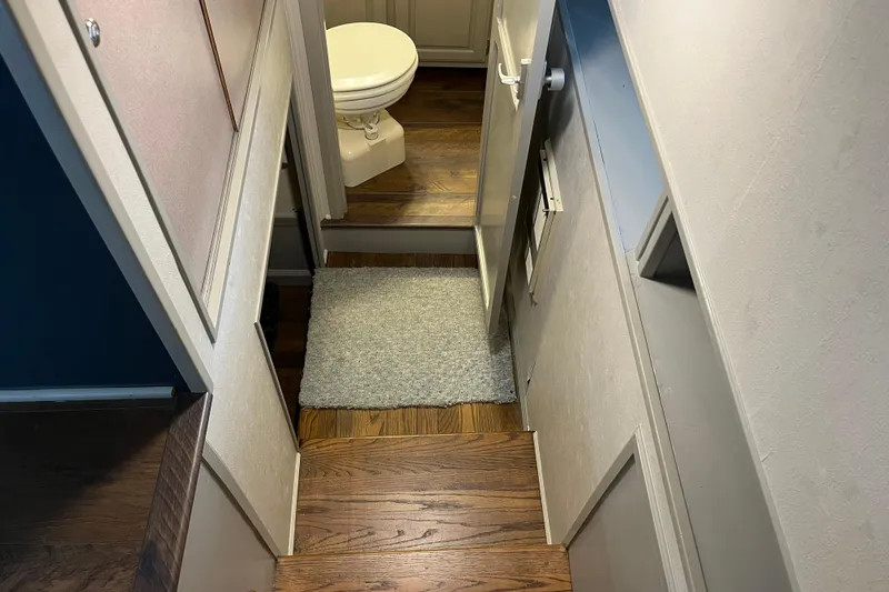 Slide: The Image of Narrow hallway with wooden steps leading to a small bathroom in a 1995 WaveLenth Wide Body. - 30
