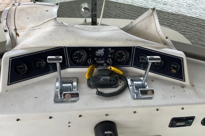 Slide: The Image of Control panel of a 1995 WaveLenth Wide Body boat with gauges and throttle levers. - 36