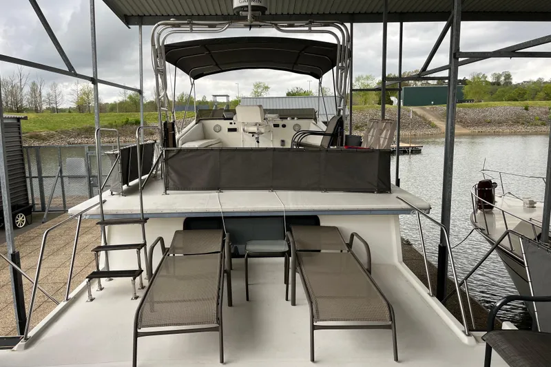 Slide: The Image of 1995 WaveLenth Wide Body boat with upper deck seating and canopy in a marina. - 39