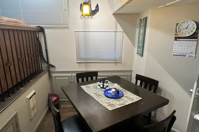 Slide: The Image of Cozy dining area in a 1995 WaveLenth Wide Body, nautical decor, wooden table, and chairs. - 8