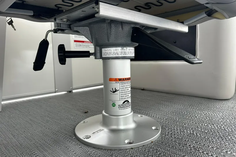 Slide: The Image of Under-seat swivel mechanism of Sweetwater EX2086S, 2026 model, featuring safety warnings and adjustment levers. - 15