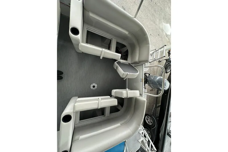 Slide: The Image of Sweetwater EX2086S 2026 boat interior with gray seating and motor, docked outdoors. - 17