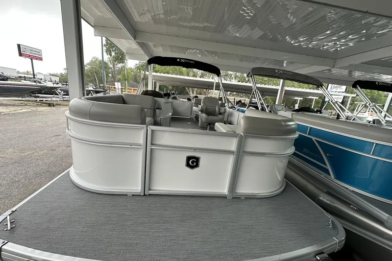 Slide: The Image of 2026 Sweetwater EX2086S pontoon boat displayed in a covered showroom area. - 3