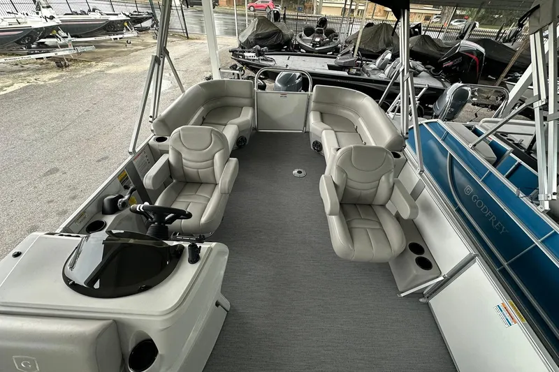 Slide: The Image of 2026 Sweetwater EX2086S pontoon boat interior with plush seating and steering console. - 8