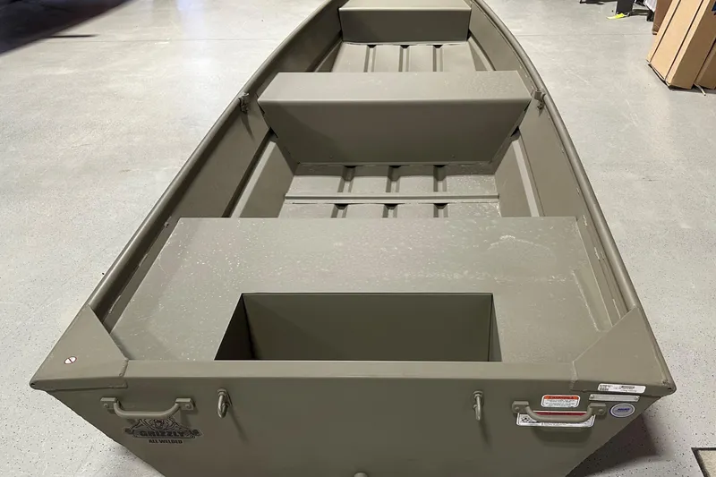 Slide: The Image of 2026 Tracker Grizzly 14 Jon boat, interior view, showcasing seating and storage compartments. - 56