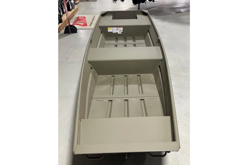 Slide: The Image of 2026 Tracker Grizzly 14 Jon boat in showroom, showcasing interior seating and design. - 58