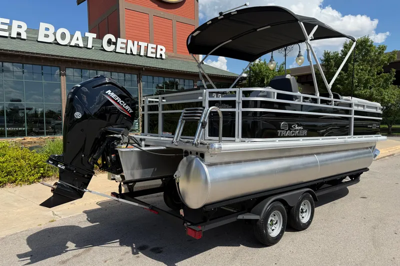 Slide: The Image of 2026 Sun Tracker SportFish 20 DLX pontoon boat with Mercury engine at a boat center. - 10