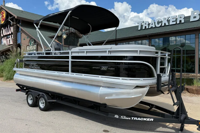 Slide: The Image of 2026 Sun Tracker SportFish 20 DLX pontoon boat on trailer outside Outdoor World store. - 11
