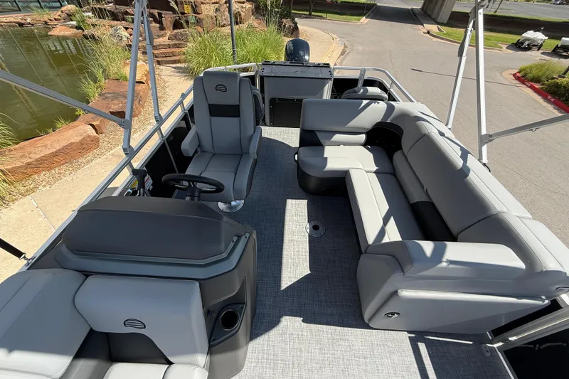 Slide: The Image of 2026 Sun Tracker SportFish 20 DLX pontoon boat interior with gray seating and steering console. - 6