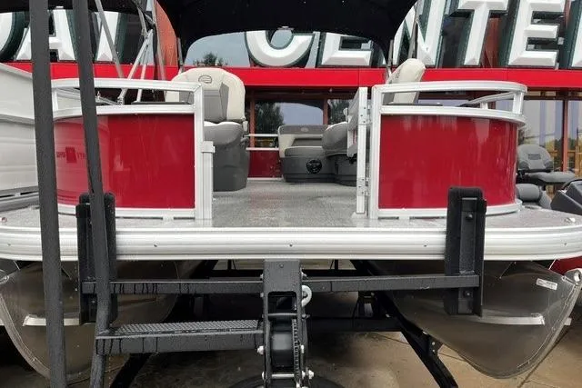 Slide: The Image of 2026 Sun Tracker Bass Buggy 16 XL Select pontoon boat, red exterior, displayed at dealership. - 2