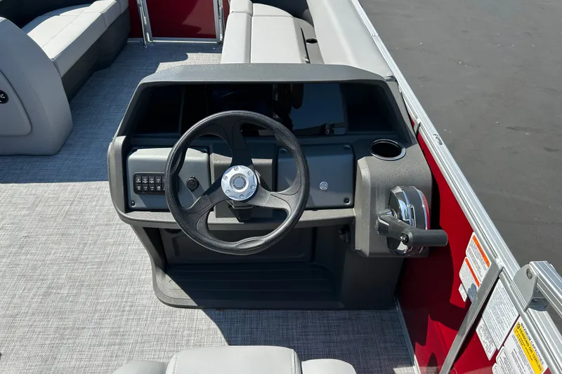 Slide: The Image of 2026 Sun Tracker Party Barge 18 DLX steering console with modern controls and seating. - 18