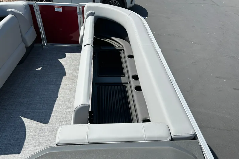 Slide: The Image of 2026 Sun Tracker Party Barge 18 DLX interior with gray seating and cup holders. - 13