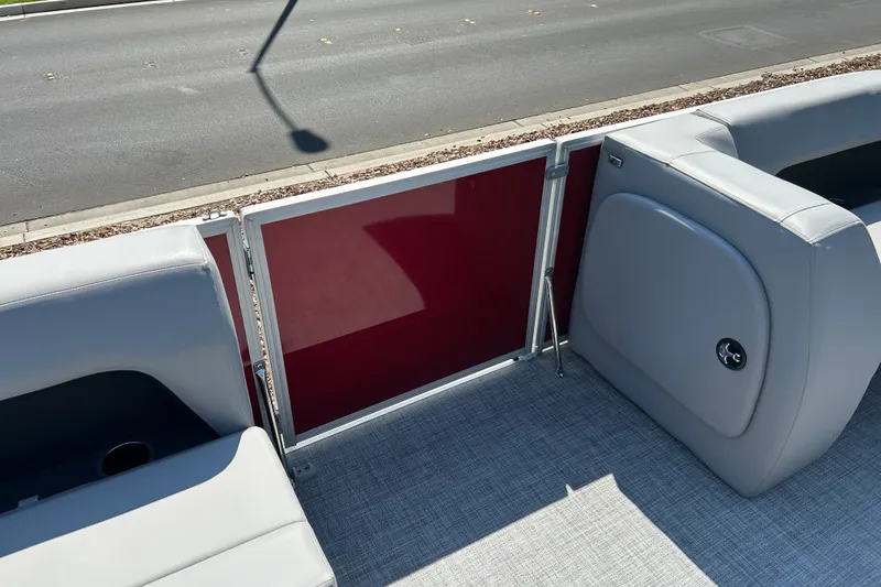 Slide: The Image of 2026 Sun Tracker Party Barge 18 DLX interior with gray seating and red paneling. - 20