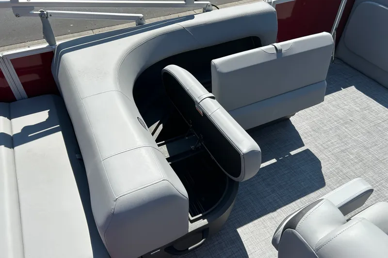Slide: The Image of 2026 Sun Tracker Party Barge 18 DLX interior with open storage compartment and seating. - 14