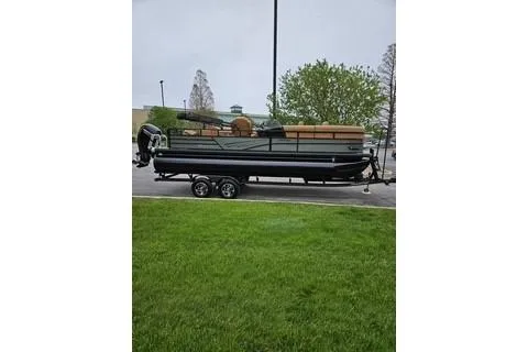 Slide: The Image of 2026 Ranger 220FC boat on trailer, parked outdoors with green grass and trees. - 62