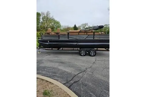 Slide: The Image of 2026 Ranger 220FC boat on trailer, parked outdoors with trees in the background. - 67