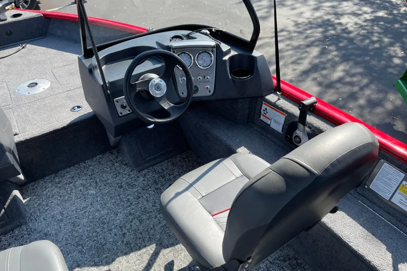 Slide: The Image of Interior of 2026 Tracker Pro Guide V-16 WT boat with steering wheel and seating. - 21