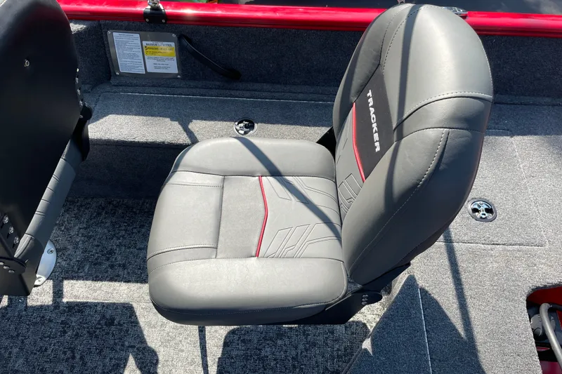 Slide: The Image of 2026 Tracker Pro Guide V-16 WT boat seat, gray upholstery with red accents, on carpeted deck. - 20