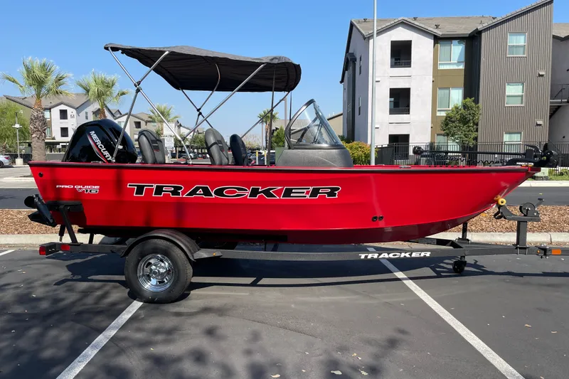 The Image of 2026 Tracker Pro Guide V-16 WT boat in a parking lot, vibrant red color. - 0