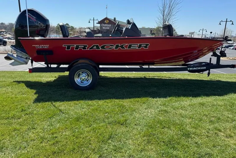 Slide: The Image of 2026 Tracker Pro Team 195 boat on trailer, parked on grass, sunny day. - 5