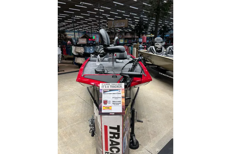 Slide: The Image of 2026 Tracker Pro 170 boat displayed in a showroom with promotional signage. - 2