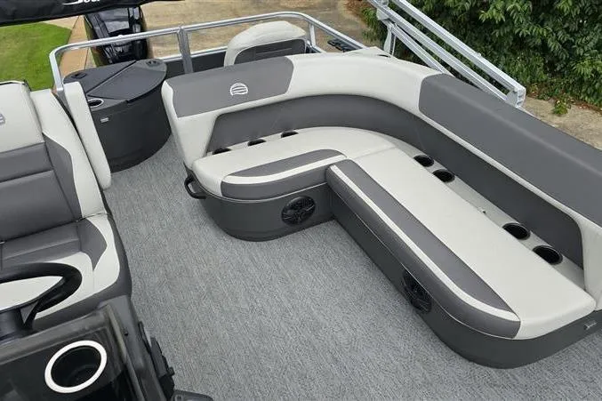 Slide: The Image of 2026 Sun Tracker Bass Buggy 18 DLX pontoon boat interior with gray seating and cup holders. - 12