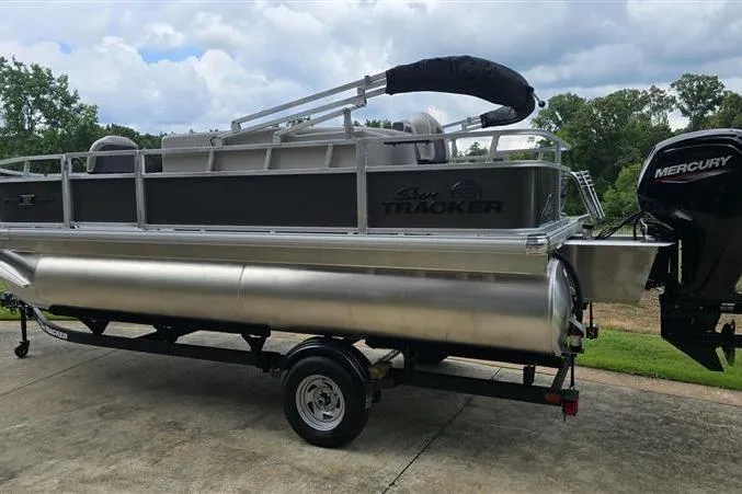 Slide: The Image of 2026 Sun Tracker Bass Buggy 18 DLX pontoon boat on trailer, featuring Mercury outboard motor. - 4