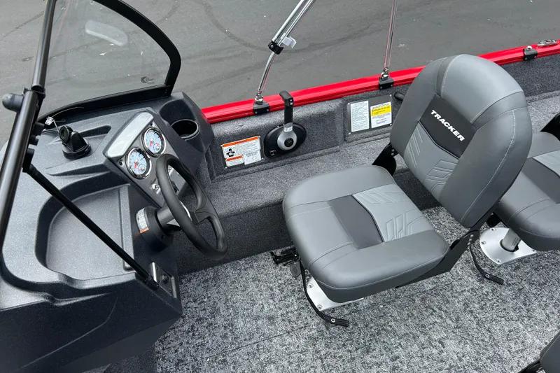 Slide: The Image of 2026 Tracker Pro Guide V-16 WT boat interior with steering wheel and gray seats. - 6