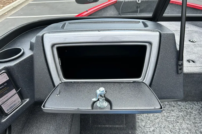Slide: The Image of 2026 Tracker Pro Guide V-16 WT boat dashboard with open storage compartment. - 11
