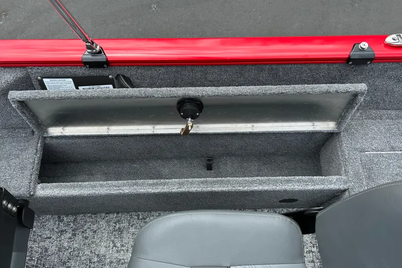 Slide: The Image of 2026 Tracker Pro Guide V-16 WT boat storage compartment with red trim and gray interior. - 15