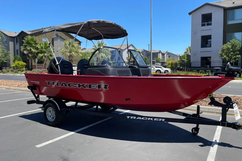 Slide: The Image of 2026 Tracker Pro Guide V-16 WT boat in a parking lot, featuring a red hull and canopy. - 2