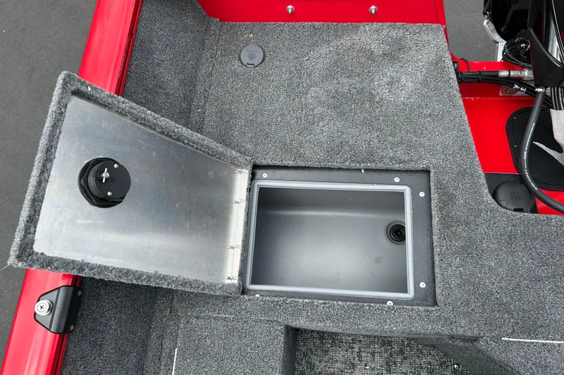 Slide: The Image of Open storage compartment on 2026 Tracker Pro Guide V-16 WT boat, featuring gray carpeted interior. - 14