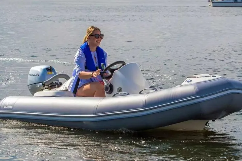 Slide: The Image of Woman driving 2026 Zodiac Yachtline 360 inflatable boat on calm water. - 6