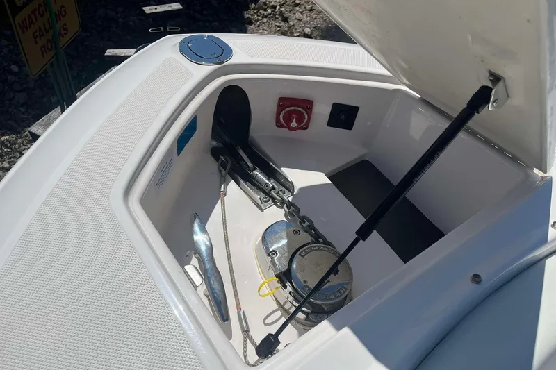 Slide: The Image of Anchor compartment of 2023 Regal 2800 Bowrider boat, open with visible chain and controls. - 20