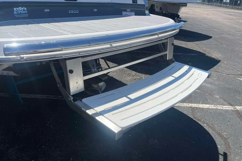 Slide: The Image of 2023 Regal 2800 Bowrider swim platform with stainless steel accents in a parking lot. - 5