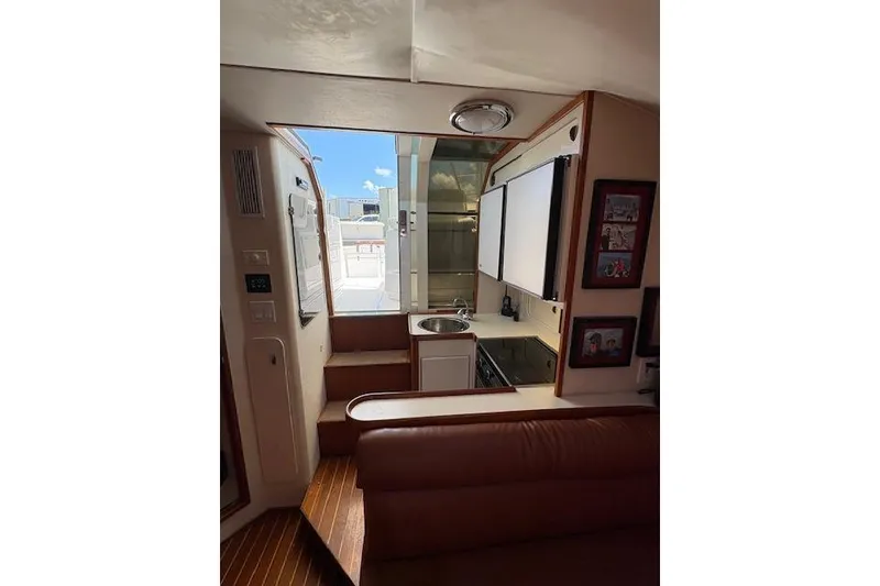 Slide: The Image of Interior of 1992 Tiara Yachts 3600 Open, featuring compact kitchen and seating area. - 11