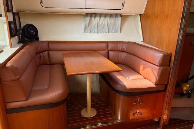 Slide: The Image of 1992 Tiara Yachts 3600 Open interior with brown leather seating and wooden table. - 12