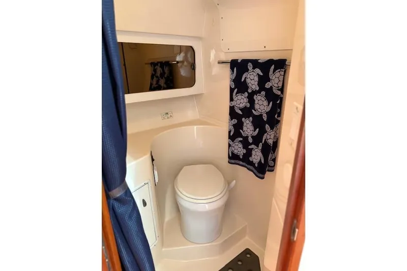Slide: The Image of Bathroom interior of 1992 Tiara Yachts 3600 Open, featuring toilet and turtle-patterned towel. - 14