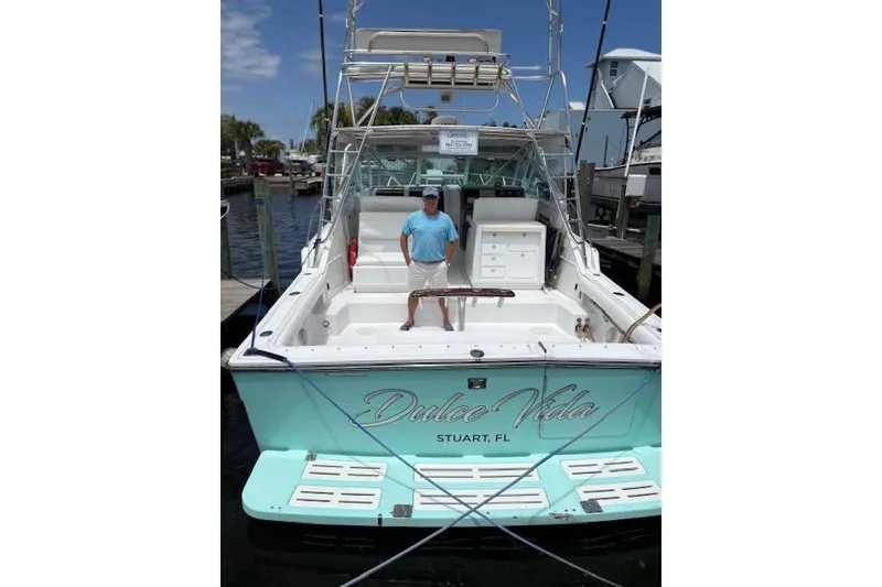 Slide: The Image of 1992 Tiara Yachts 3600 Open boat docked, featuring "Dulce Vida" name and a person onboard. - 18