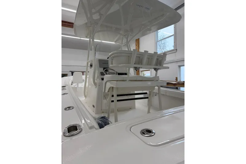 Slide: The Image of 2017 Regulator 23 boat interior with seating and console in a showroom. - 2